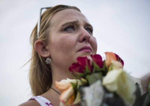 Kimberly Osteen, 31, of San Antonio, sobs as she holds a bouquet...